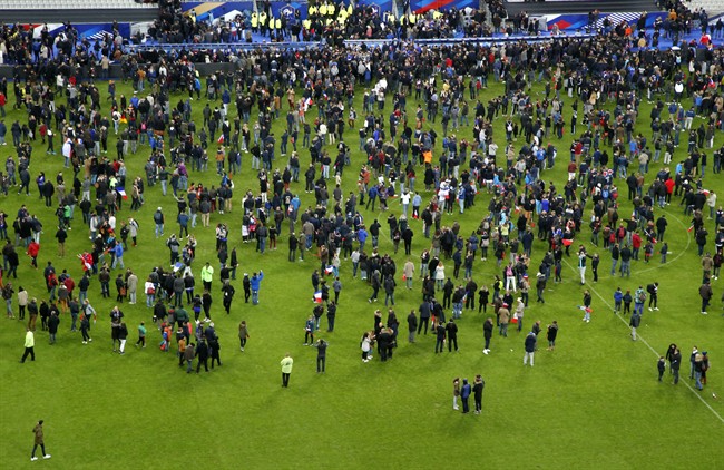 Spectators invaded the pitch of the Stade de France stadium after explosions were heard during the international friendly soccer France against Germany, Friday, Nov. 13, 2015 in Saint Denis, outside Paris.