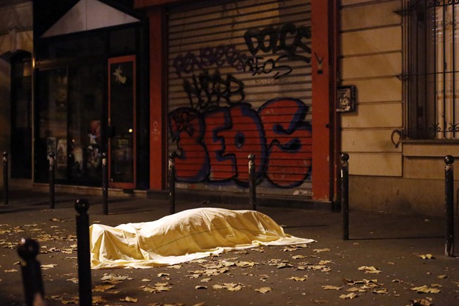 In this Nov. 13, 2015 file photo a victim of an attack in Paris lays dead outside the Bataclan theater, Paris. The attacks killed 130 people, injured over 300, and caused the French president to declare his nation at war with Islamic State extremists.