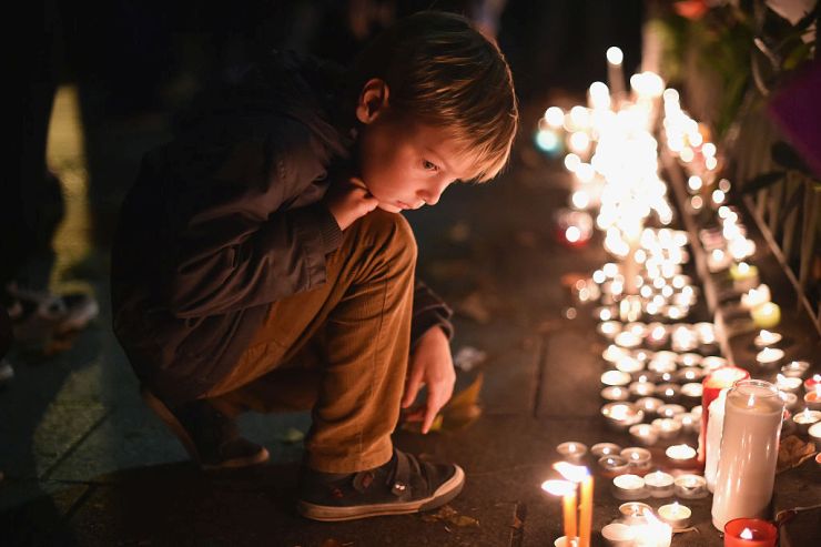PARIS, FRANCE - NOVEMBER 16: A young boy views tributes left opposite the main entrance of Bataclan concert hall as French police lift the cordon following Fridays terrorist attacks on November 16, 2015 in Paris, France. 