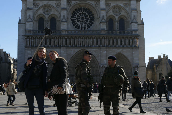French soldiers stand by as tourists take selfies in Notre Dame Cathedral, in Paris, France, Sunday, Nov. 22. 
