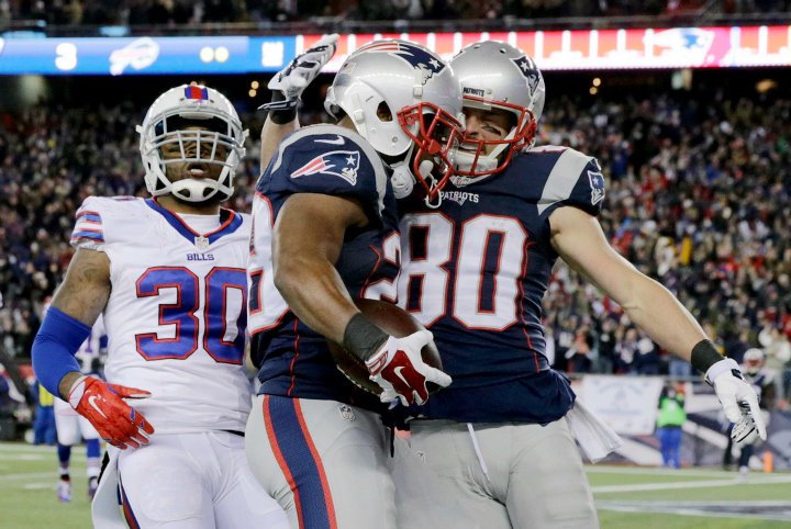 New England Patriots running back James White, centre, celebrates his touchdown with wide receiver Danny Amendola (80) in front of Buffalo Bills safety Bacarri Rambo (30) in the first half of an NFL football game, Monday, Nov. 23, 2015, in Foxborough, Mass.