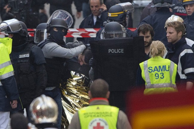 Hooded police officers detain a man in Saint-Denis, near Paris, Wednesday, Nov. 18, 2015. 
