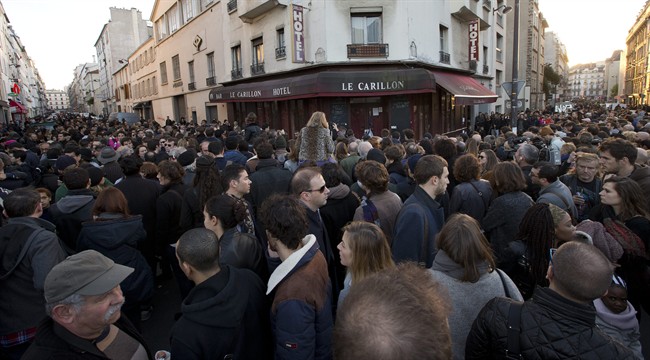 People pay their respect to the victims at the site of the attacks on restaurant Le Petit Cambodge (Little Cambodia) and the Carillon Hotel on the first of three days of national mourning in Paris, Sunday, Nov. 15, 2015. 