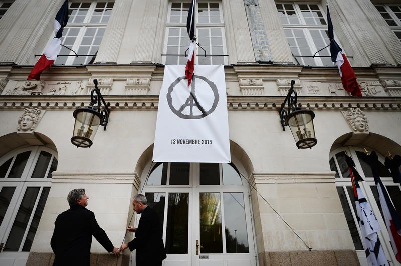 A drawing of French artist Jean Jullien named 'Peace for Paris' is hung on the Nantes cityhall as people observe a minute of silence in tribute to the victims of the attacks in Paris on November 16, 2015.