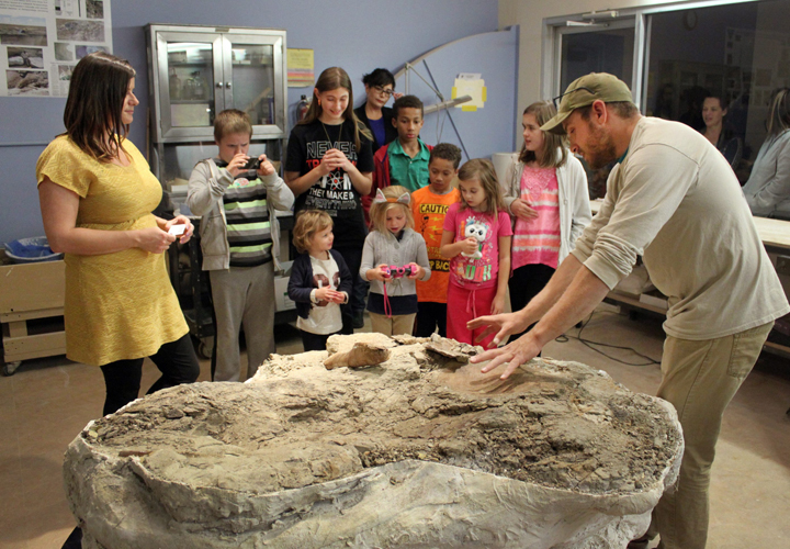 Tom Suazo, right, a fossil predator with the New Mexico Museum of Natural History and Science, tells a group of children about the museum’s latest find as discover Amanda Cantrell, left, listens during a public unveiling in Albuquerque, N.M., on Thursday, Nov. 5, 2015.