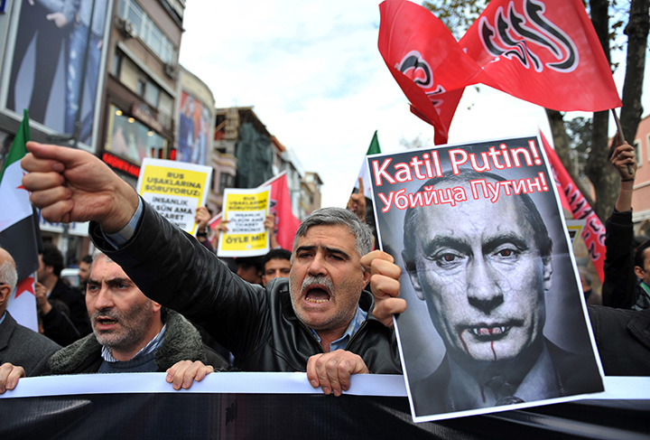 Turkish protesters shout anti-Russia slogans as they hold a poster of Russian President Vladimir Putin that reads in Turkish and Russian "Assassin Putin!" during a protest in Istanbul, Turkey, Friday, Nov. 27, 2015. 