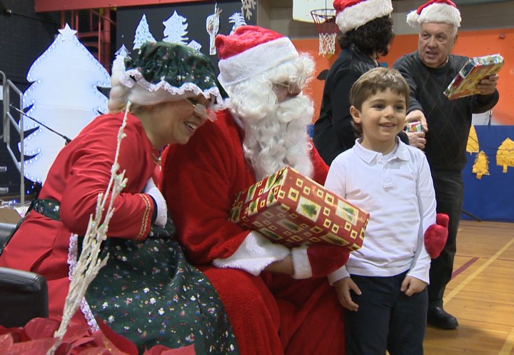 Mr. and Mrs. Claus take pictures with children for the Generations' Holiday Food and Toy Drive.