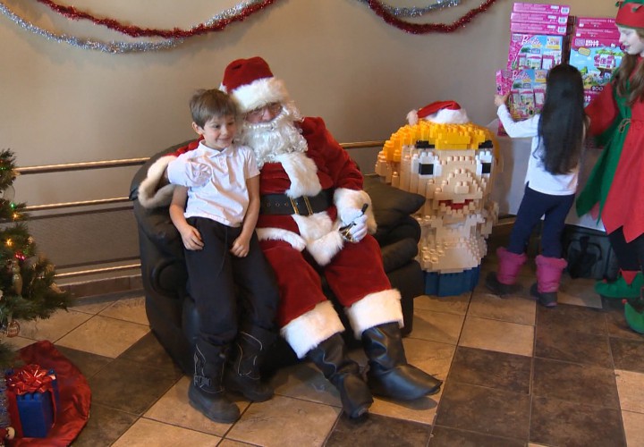 A child tells Santa what he wants for Christmas before posing for a photo for the Generations' Holiday Food and Toy Drive.