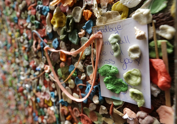 A note that reads "Goodbye gum wall, we will miss you," sticks to a wall partially obscured by gum, Monday, Nov. 9, 2015, at Seattle's "gum wall" at Pike Place Market. Besides gum, people leave pictures, business cards and other mementos. 