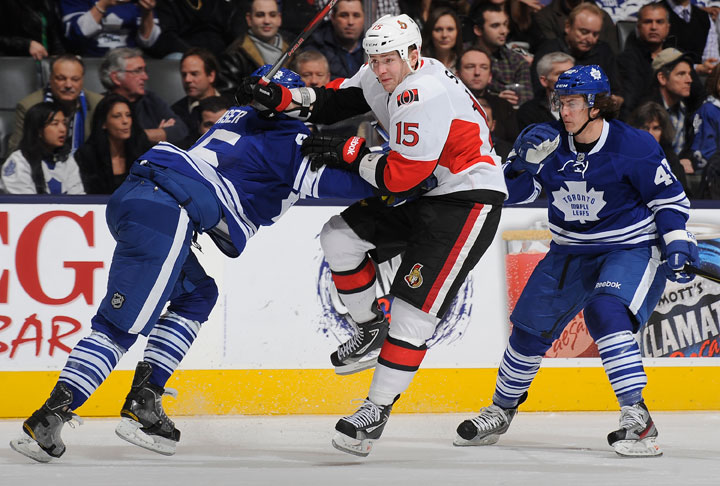 Zack Smith #15 of the Ottawa Senators jumps between Mark Fraser #45 and Tyler Bozak #42 of the Toronto Maple Leafs during NHL game action March 6, 2013 at the Air Canada Centre in Toronto