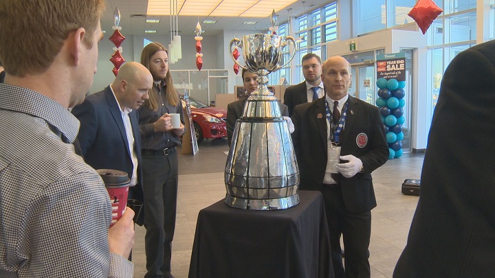 Grey Cup handler Jeff McWhinney educates fans on the CFL championship trophy.