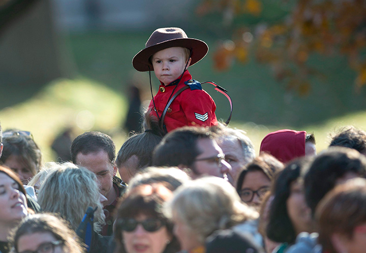 A youngster wearing a Mountie uniform waits for Prime Minister-designate Justin Trudeau and the Members of Parliament who will comprise his cabinet to arrive at Rideau Hall for a swearing-in ceremony in Ottawa on Wednesday, Nov. 4, 2015.