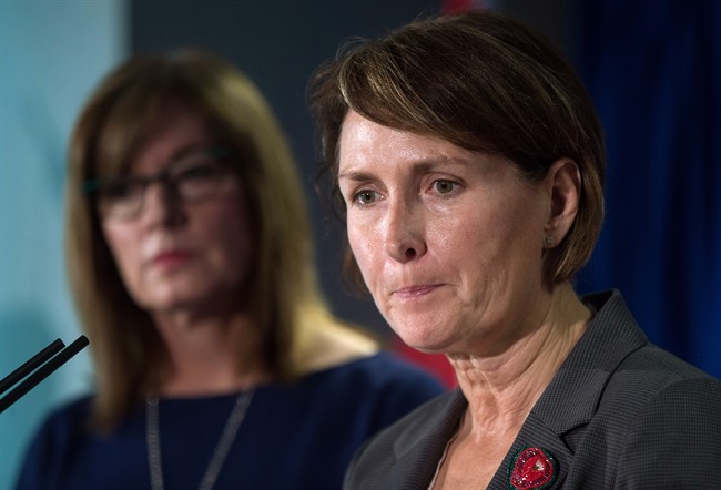 B.C. Representative for Children and Youth Mary Ellen Turpel-Lafond pauses while speaking as B.C. Information and Privacy Commissioner Elizabeth Denham, back, listens after releasing a joint report about cyberbullying in Vancouver, B.C., on November 13, 2015.