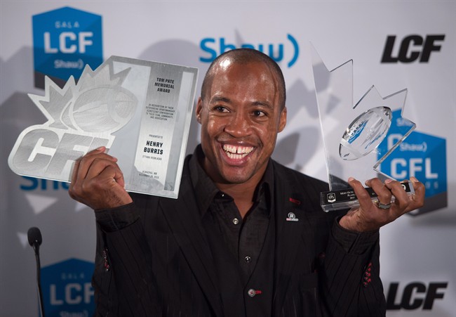 Ottawa Redblacks quarterback Henry Burris poses for photographs after winning the CFL's most outstanding player award and Tom Pate memorial award during the Canadian Football League awards in Winnipeg on Thursday November 26, 2015. 