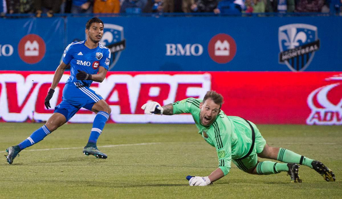 Montreal Impact's Johan Venegas, left, scores against Columbus Crew SC's goalkeeper Steve Clark.
