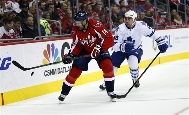 Washington Capitals right wing Justin Williams (14) goes after the puck with Toronto Maple Leafs defenseman Roman Polak (46), from the Czech Republic, in the first period of an NHL hockey game, Saturday, Nov. 7, 2015, in Washington.