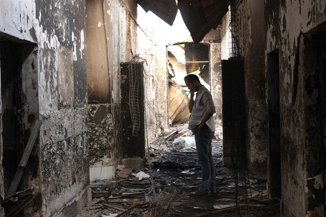 FILE - In this Friday, Oct. 16, 2015, file photo, an employee of Doctors Without Borders walks inside the charred remains of their hospital after it was hit by a U.S. airstrike in Kunduz, Afghanistan. 