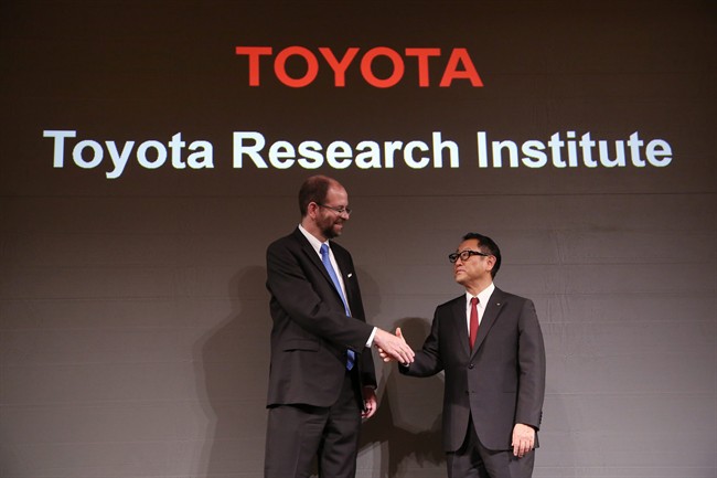 Toyota Motor Corp.'s Executive Technical Advisor Gill Pratt, left, and President Akio Toyoda, right, shake hands during a press conference on artificial intelligence in Tokyo, Friday, Nov. 6, 2015. Toyota is investing $1 billion in a research company it's setting up in Silicon Valley to develop artificial intelligence and robotics, underlining the Japanese automaker's determination to lead in futuristic cars that drive themselves and apply the technology to other areas of daily life. 