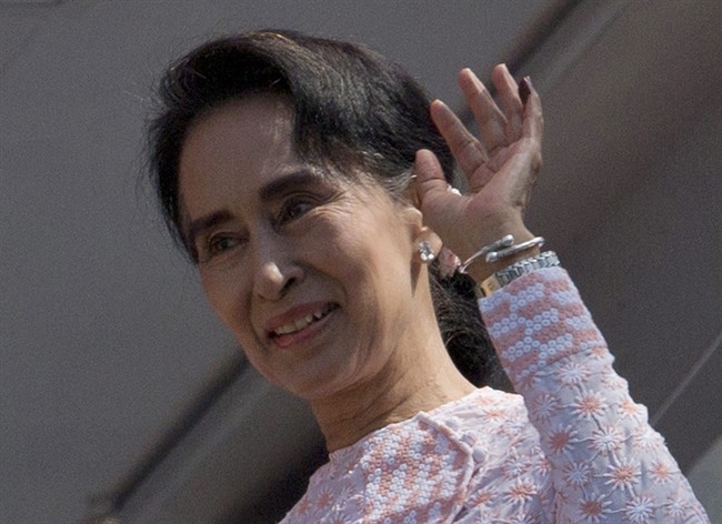 Myanmar's opposition National League for Democracy party leader Aung San Suu Kyi, with ink still imprinted on the little finger of her left hand after voting yesterday, waves after delivering a speech from a balcony of the NLD headquarters in Yangon, Myanmar, Monday, Nov. 9, 2015.