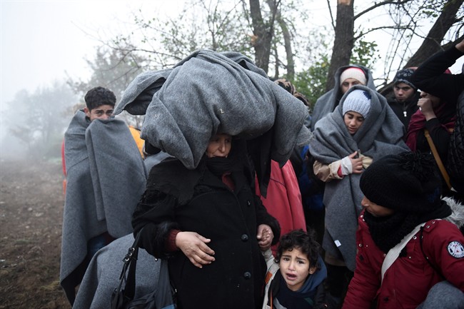 Refugees wait to be allowed to cross from the northern Greek village of Idomeni to southern Macedonia, on Friday, Nov. 20, 2015. 