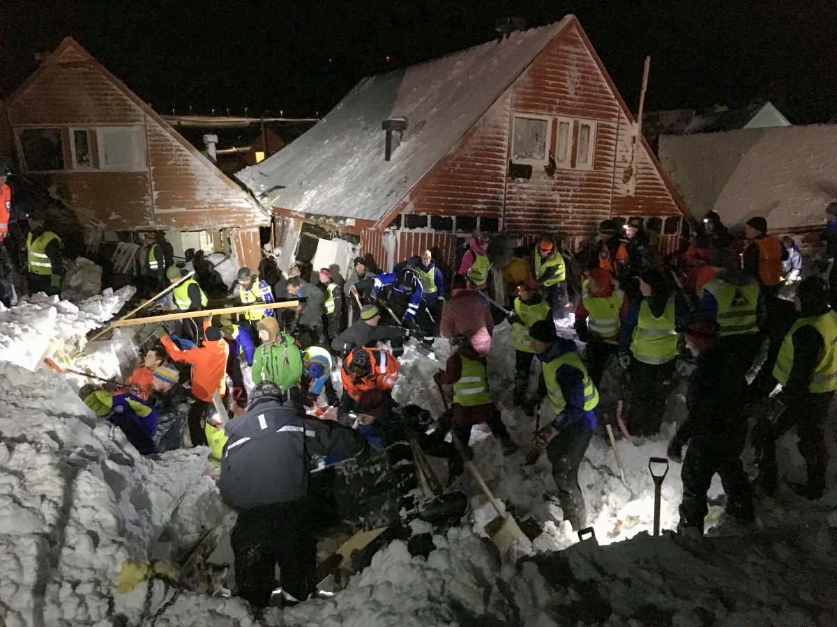 Search and rescue crews work after an avalanche hit several houses in Longyearbyen, Norway, Saturday Dec. 19. 2015.  It is unclear about the number of people caught in the avalanche but authorities are calling for volunteers with shovels to help in the search to locate victims. 