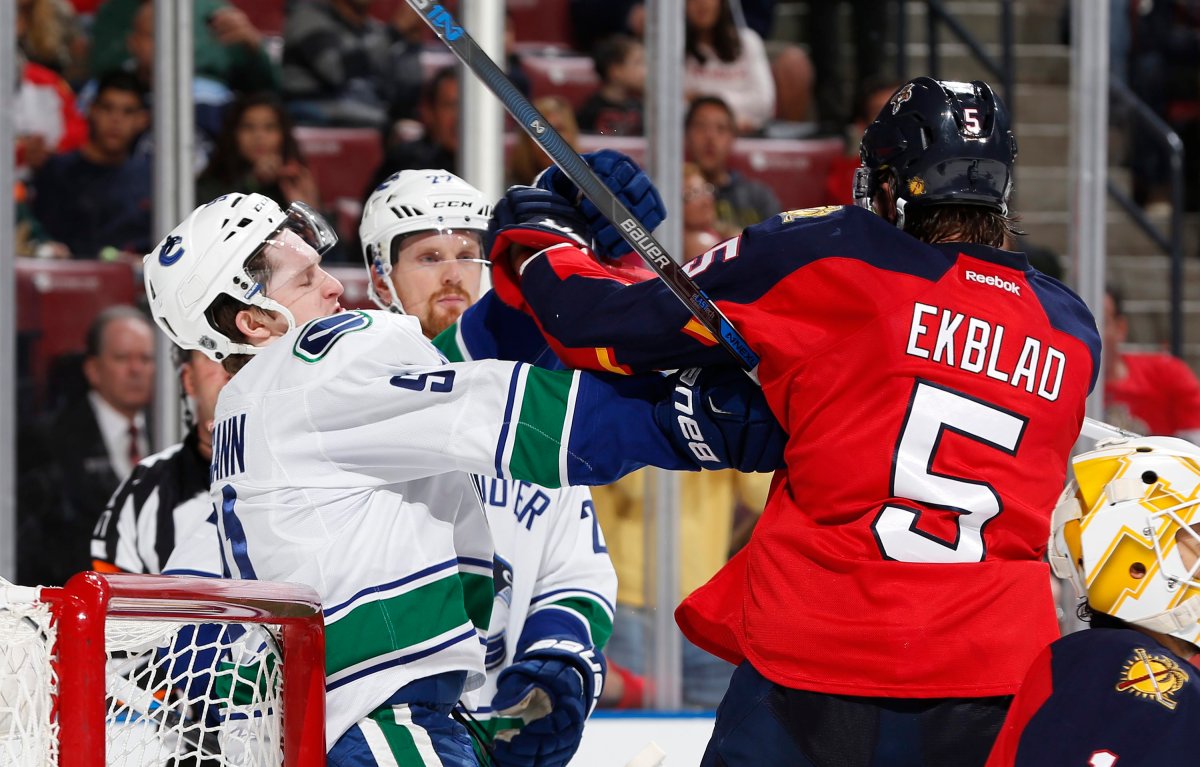 Vancouver Canucks center Jared McCann and Florida Panthers defenseman Aaron Ekblad tangle at the side of the net during the second period. 