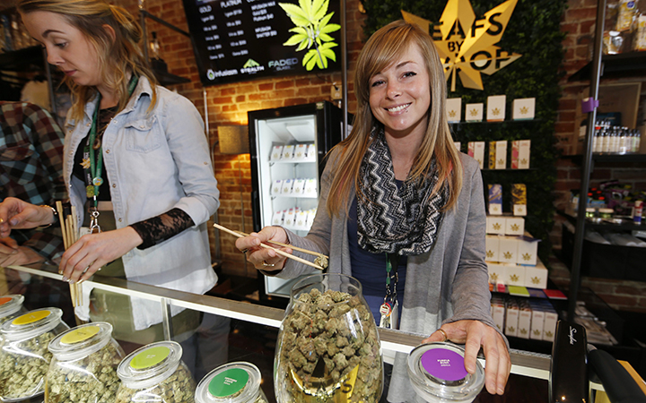 LivWell store manager Carlyssa Scanlon shows off some of the products available in the marijuana line marketed by rapper Snoop Dogg in one of the marijuana chain's outlets south of downtown Denver. LivWell grows the Snoop pot alongside many other strains on its menu.