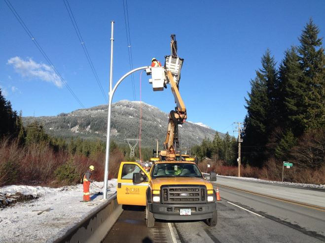Crews installing a variable speed sign along a BC Highway