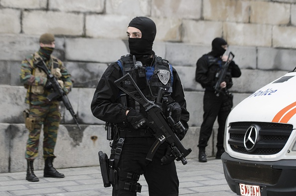 Belgian police officers and soldiers stand guard outside the Brussels Palace on November 20, 2015.  