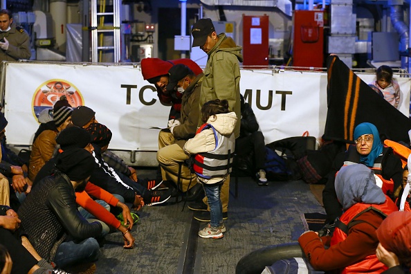 Refugees are seen in Turkish Coast Guard ship TCSG Umut (Hope) on December 10, 2015 after a total of 152 refugees and asylum seekers were detained off the coast of Cesme district of Izmir province as they attempted to reach the nearby Greek islands. (Photo by Cem Oksuz/Anadolu Agency/Getty Images).