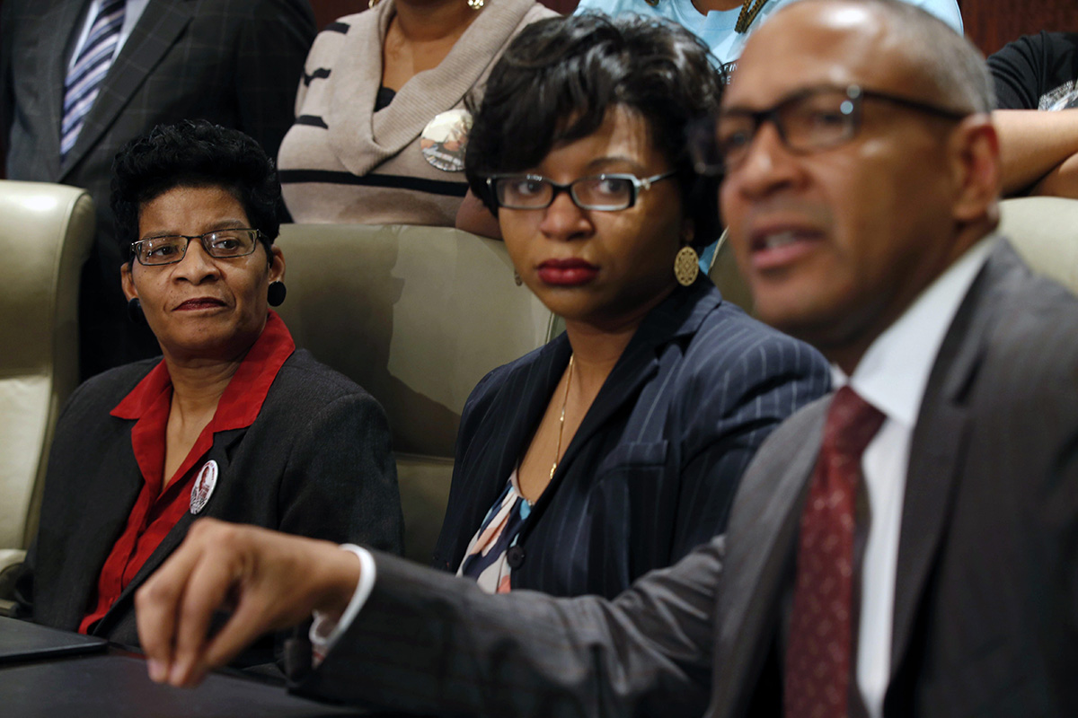 Geneva Reed-Veal, left, and Sharon Cooper, center, the mother and sister of Sandra Bland, listen to attorney Larry Rogers Jr., right, explain concerns about the Texas grand jury's role in the death of Naperville resident Sandra Bland, Monday, Dec. 21, 2015 in Chicago.