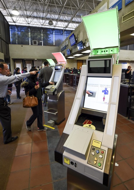Pedestrians crossing from Mexico into the United States at the Otay Mesa Port of Entry wait to use at a biometric kiosks Thursday, Dec. 10, 2015, in San Diego. On Thursday, U.S. Customs and Border Protection began capturing facial and eye scans of foreigners entering the country at San Diego's Otay Mesa port of entry on foot. (AP Photo/Denis Poroy).