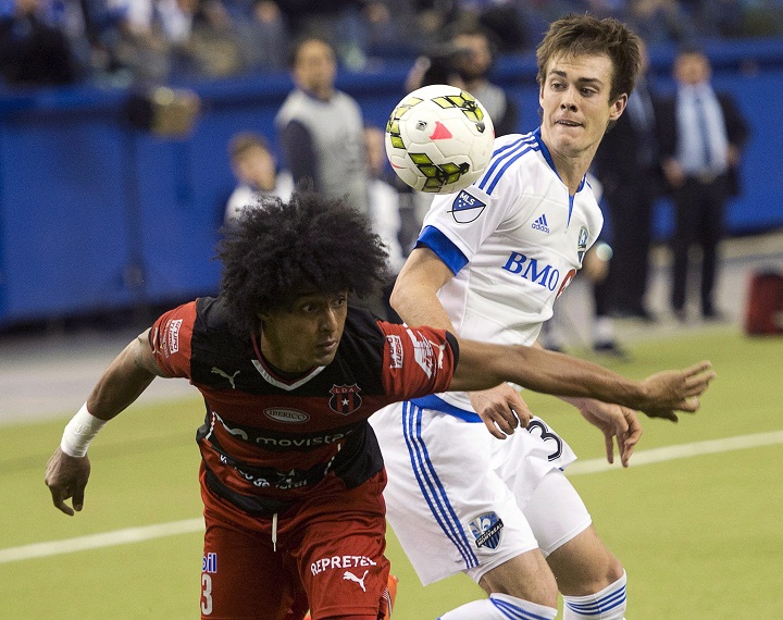 Montreal Impact's Cameron Porter, right, and LD Alajuelense's Porfirio Lopez keep their eyes on the ball during second half CONCACAF semi-final soccer action Wednesday, March 18, 2015 in Montreal.