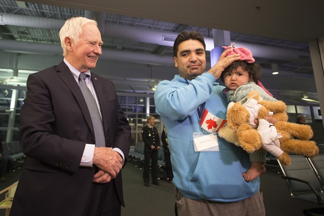 Governor General David Johnston meets Syrian refugee Osama and his baby daughter as they arrive at the Welcome Centre at Toronto's Pearson Airport on Friday December 18, 2015. A new report examines the experiences of Canada's Syrian refugees.