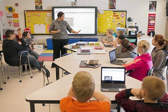 A teacher instructs students in a classroom. 