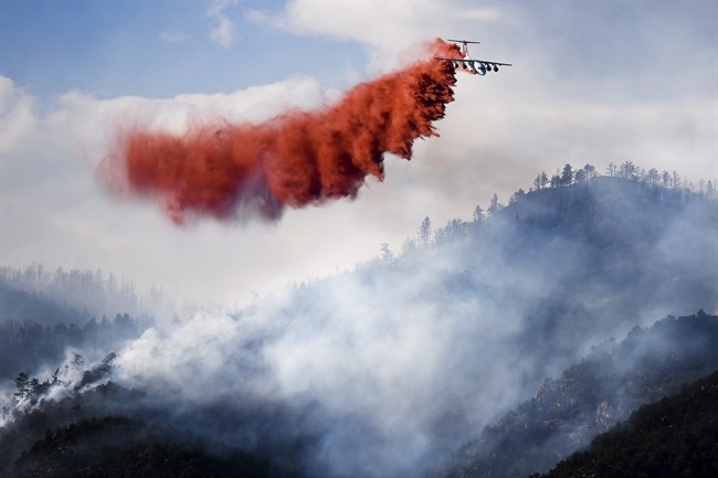 In this June 27, 2014, file photo, aa slurry bomber makes a drop on the Eightmile Fire, north of Canon City, Colo. 