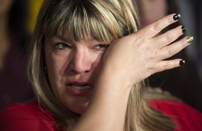 Bernadette Smith, from Winnipeg, wipes away tears as she talks about the Missing and Murdered Indigineous Women inquiry Tuesday December 8, 2015 on Parliament Hill in Ottawa. THE CANADIAN PRESS/Adrian Wyld.