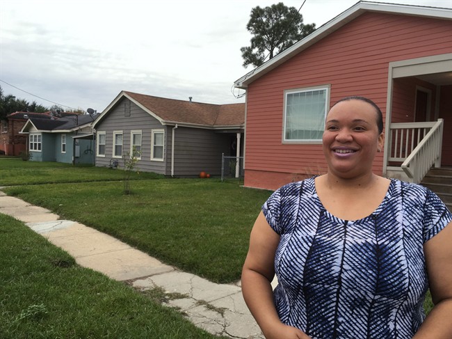 Sheldonna Durosseau, 34, stands outside the home she shares with her daughter in a flood-damaged area of New Orleans that's now being rebuilt, partly through a Habitat for Humanity program funded by a trade treaty with Canada, on Wednesday, Dec. 2, 2015.