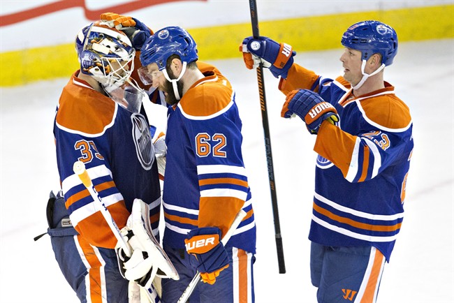 Edmonton Oilers' goalie Anders Nilsson (39), Eric Gryba (62) and Matt Hendricks (23) celebrate the win over the Buffalo Sabres during third period NHL action in Edmonton, Alta., on Sunday December 6, 2015. 