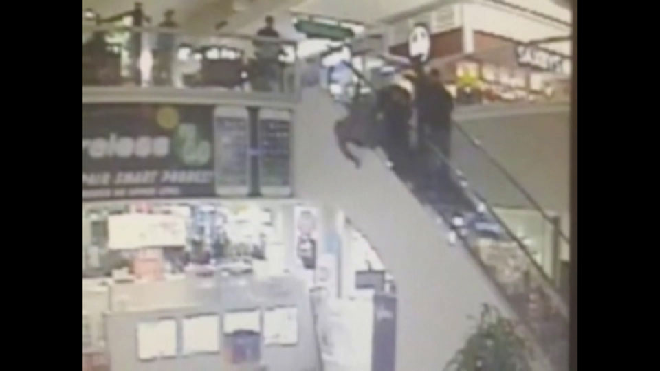 Caught on camera: man jumps over side of escalator while trying to flee police - image