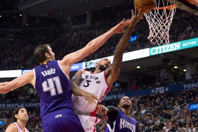 Toronto Raptors forward James Johnson (3) drives to the hoop through stiff defence from Sacramento Kings centre Kosta Koufos (41) and forward Rudy Gay (right) during first half NBA action in Toronto Sunday, December 20,2015. THE CANADIAN PRESS/Frank Gunn.