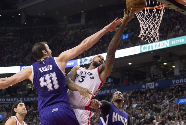 Toronto Raptors forward James Johnson (3) drives to the hoop through stiff defence from Sacramento Kings centre Kosta Koufos (41) and forward Rudy Gay (right) during first half NBA action in Toronto Sunday, December 20,2015. THE CANADIAN PRESS/Frank Gunn.