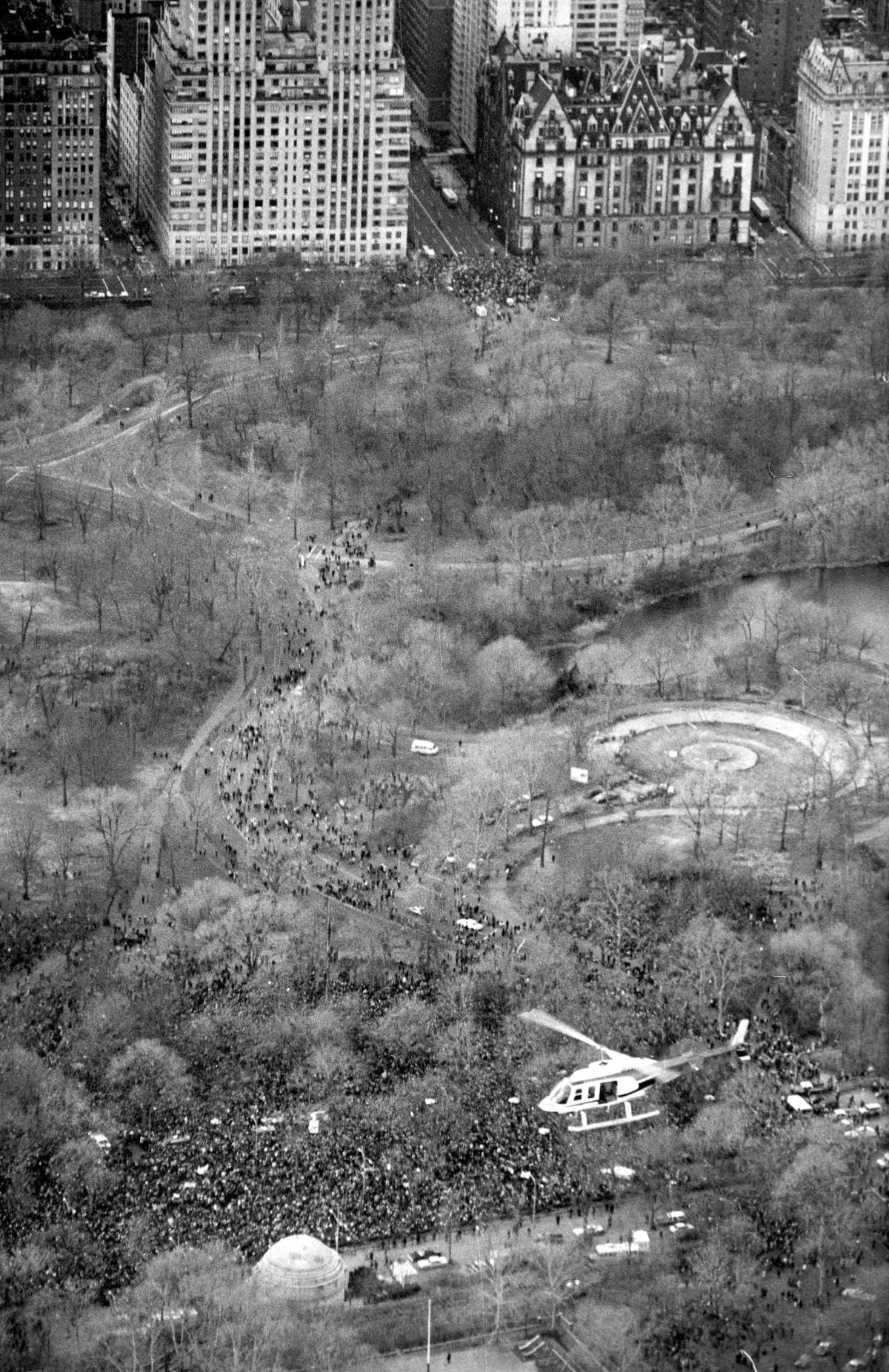 FILE – In this Dec. 14, 1980, file photo, a helicopter flies over Central Park in New York where an estimated crowd of between 50,000 to 100,000 people gathered to pay tribute to the late John Lennon. Thirty-five years ago in Dec. 8, Mark David Chapman shot and killed Lennon, a former Beatles member. (AP Photo/Dave Pickoff, File)