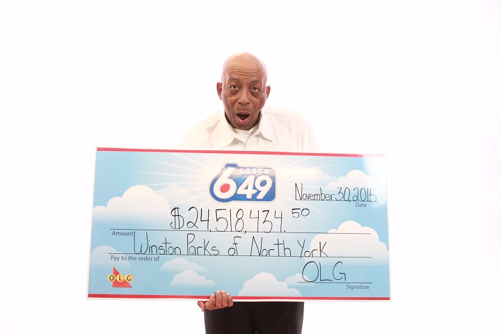 Winston Parks collects his $24.5 million LOTTO 6/49 jackpot cheque in Toronto.
