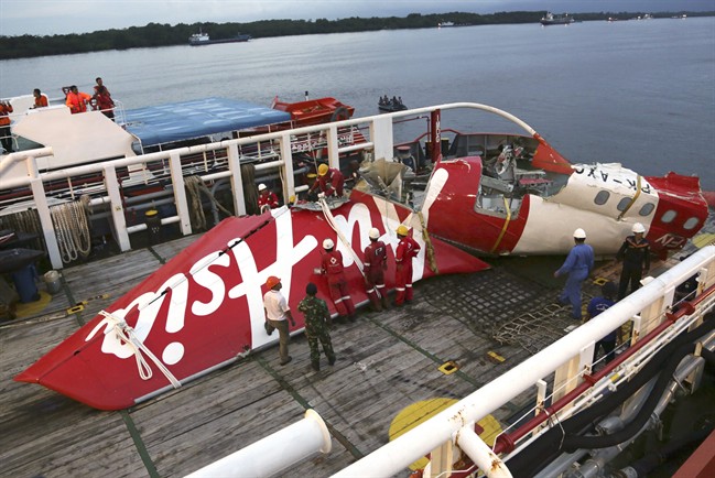 FILE - In this Sunday, Jan.11, 2015 file photo, crew members of Crest Onyx recovery ship prepare to unload the newly-recovered tail section of crashed AirAsia Flight 8501 at Kumai port in Pangkalan Bun, Central Borneo, Indonesia. Indonesian investigators say a faulty rudder control system and the pilots' response led to the crash of the plane last year that killed all 162 people on board. The National Transportation Safety Committee announced Tuesday, Dec. 1, 2015, that an analysis of Flight 8501's data recorder showed that the Airbus A320 had problems with its rudder control system while flying between the Indonesian city of Surabaya and Singapore on Dec. 28. (AP Photo/Achmad Ibrahim, File).