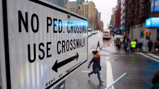 A "No Pedestrian Crossing" sign is pictured here on a busy street. 