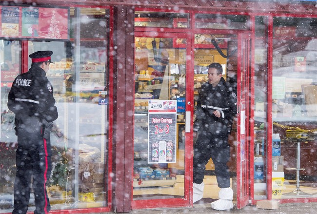 Homicide detectives investigate at a Mac's convenience store in Edmonton on Friday, December 18, 2015. A 13-year-old cried as he appeared briefly in youth court accused of killing two convenience store clerks.The boy, who cannot be identified, faces charges that include first-degree murder and robbery.THE CANADIAN PRESS/John Ulan.