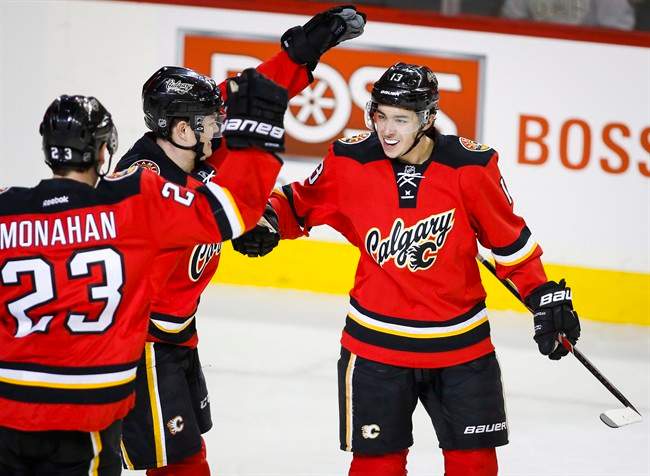 Calgary Flames' Johnny Gaudreau, right, celebrates his goal with teammates Sean Monahan, left, and Jiri Hudler, from the Czech Republic, during first period NHL hockey action against the Winnipeg Jets in Calgary, Tuesday, Dec. 22, 2015.