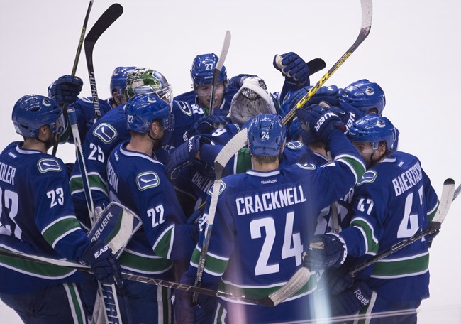 The Vancouver Canucks celebrate Jannik Hansen's game winning goal following sudden death overtime against the Edmonton Oilers during NHL action Vancouver, B.C. Saturday, Dec. 26, 2015. 