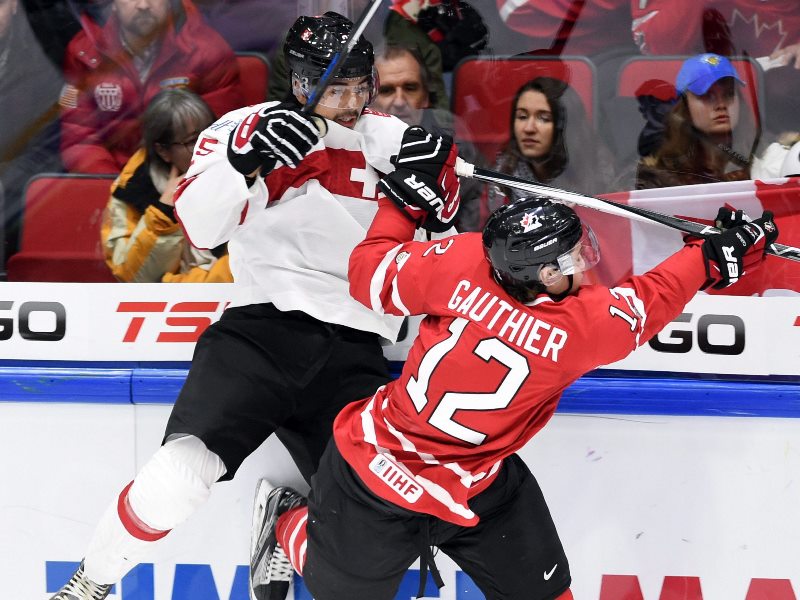 Canada's Julien Gauthier hits Switzerland's Jonas Siegenthaler into the boards during first period preliminary round hockey action at the IIHF World Junior Championship in Helsinki, Finland on Tuesday, December 29, 2015. 